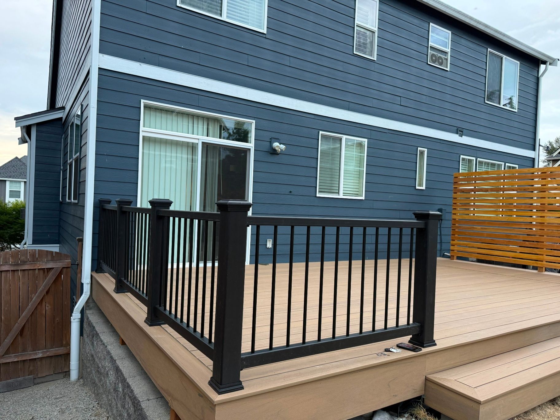 Completed deck with black railings and a horizontal cedar privacy screen