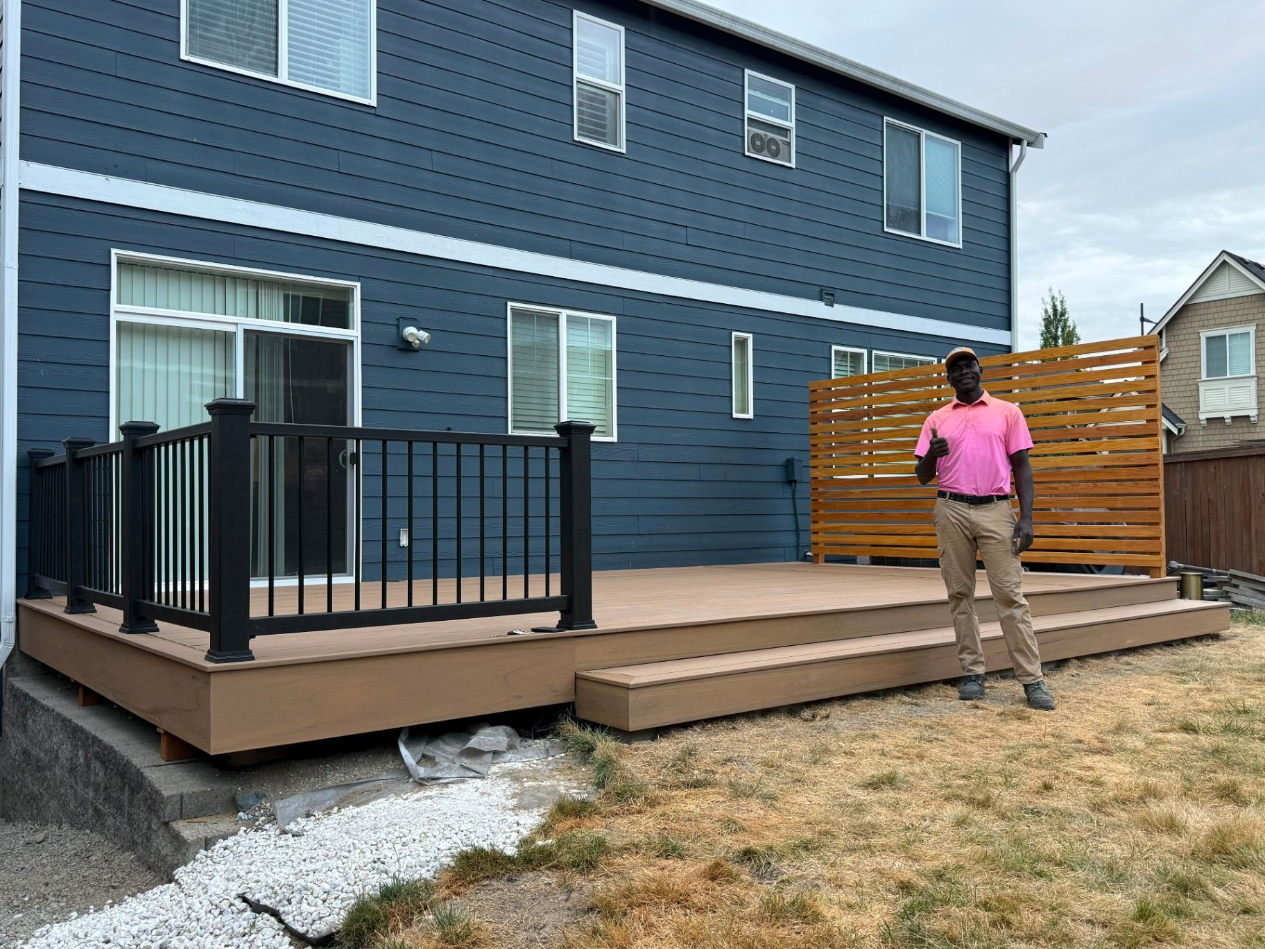 Close view of deck stairs and dark railing posts framed by trees